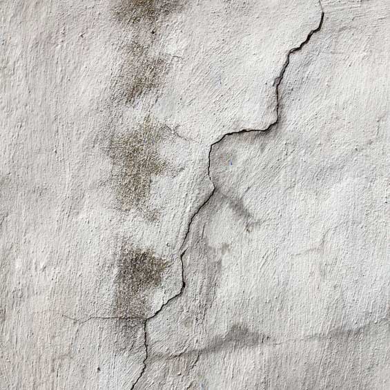 MDS-bautenschutz-bausanierung-frankurt-riss_in_der_wand Deutlicher Riss in verputzter Wand mit dunklen Feuchtigkeitsflecken – Anzeichen für Bauschäden und mögliche Durchfeuchtung.